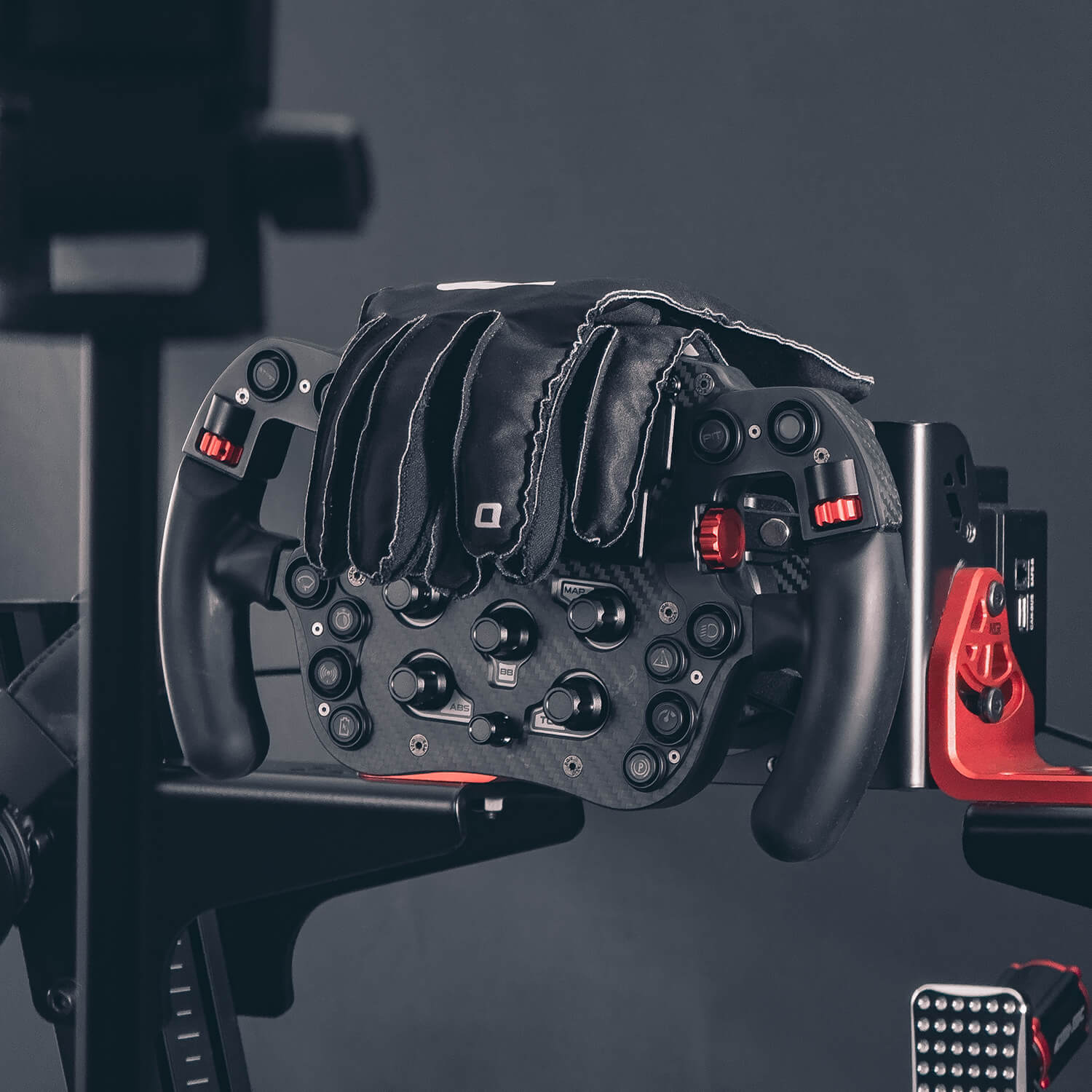 Outlap ProGrip Black Sim Racing Gloves hanging on sim racing wheel