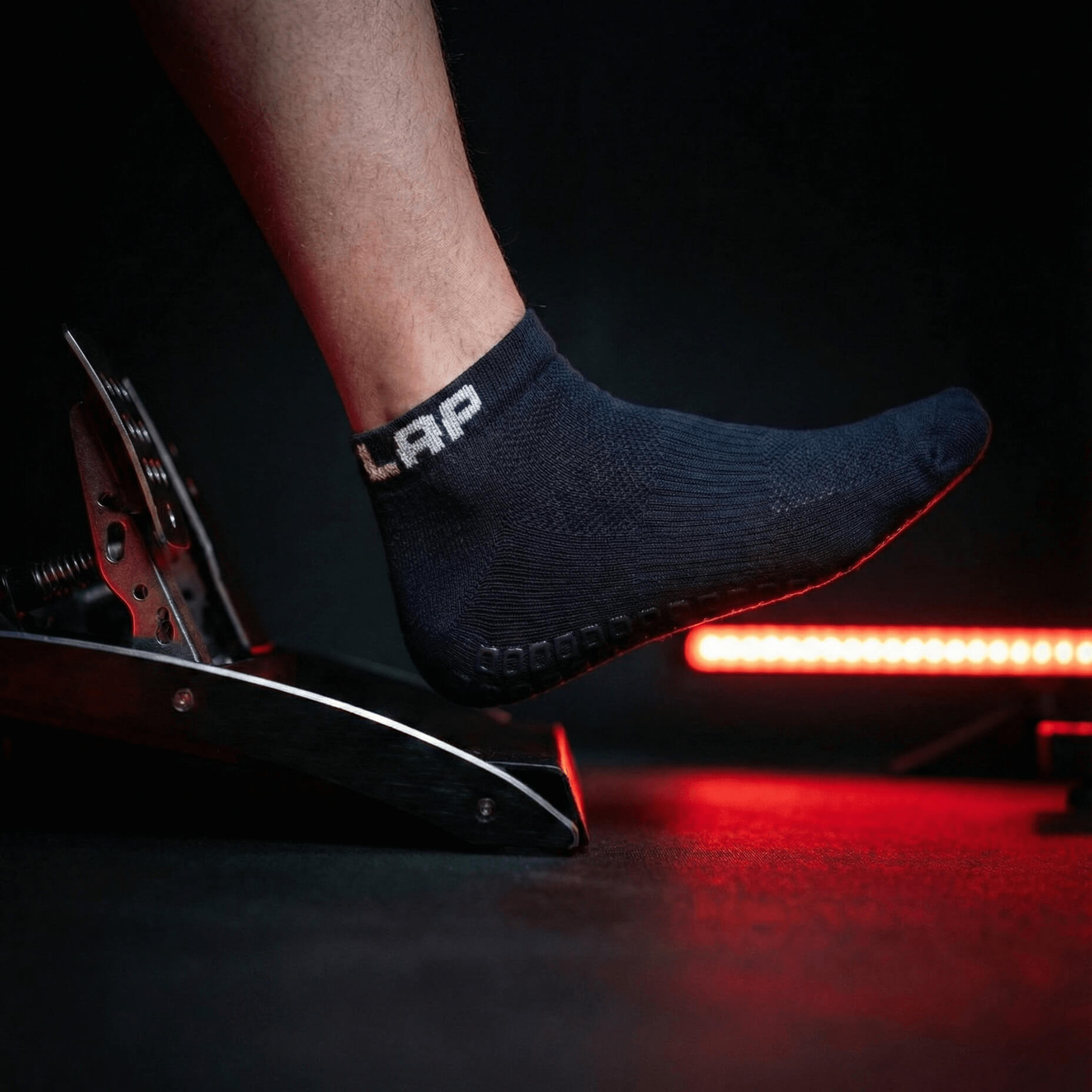 Outlap NitroGrip Obsidian Sim Racing Socks with red led light in the background